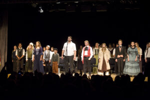 A group of people on stage in front of an audience.