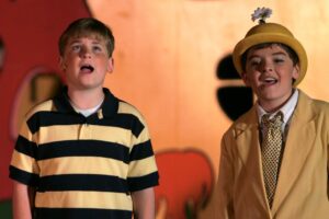 Two boys singing in a play.