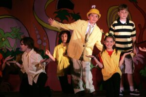 A group of kids in costumes on stage.